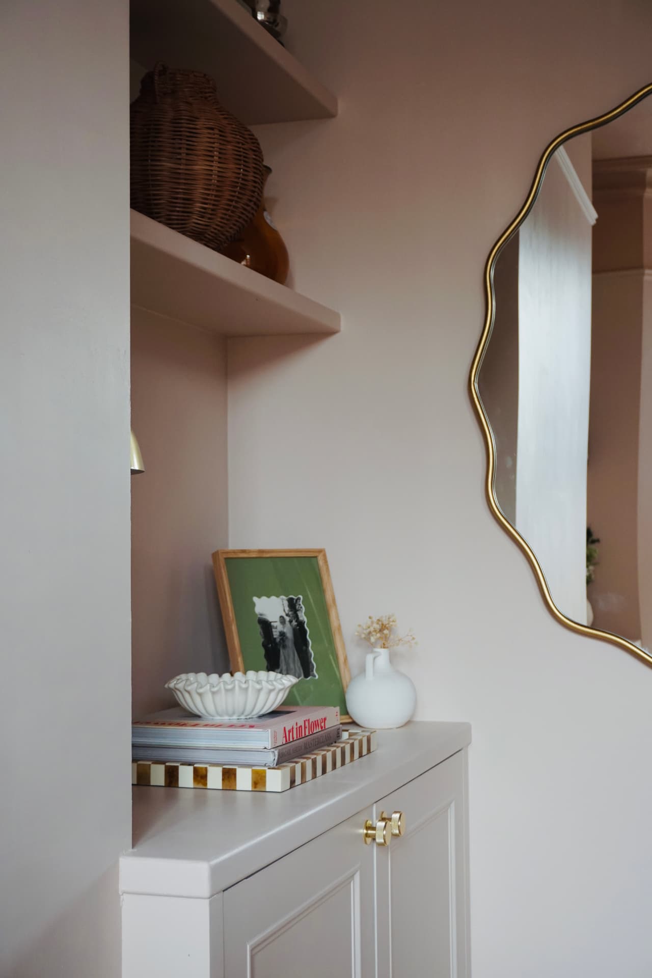 Lounge with a rust velvet sofa, built-in shelves and soft pink walls