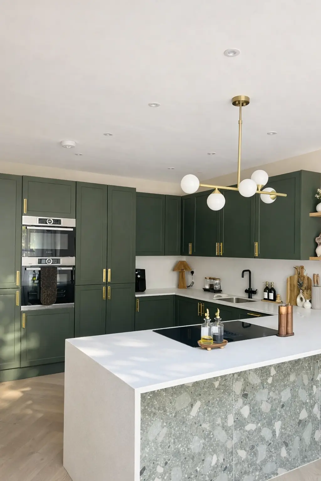 Open-plan kitchen and living space with dark green cabinetry and oak shelves