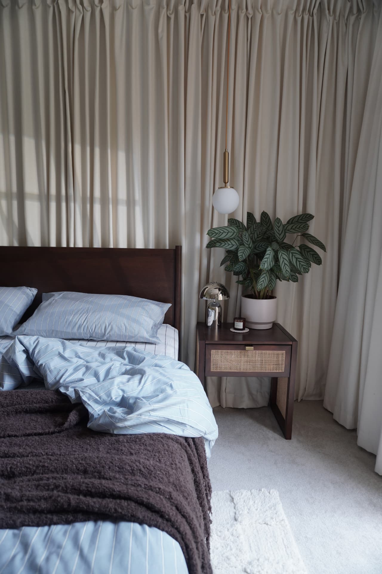 Curtain room with cream curtains, blue bedding and a dark wood bed