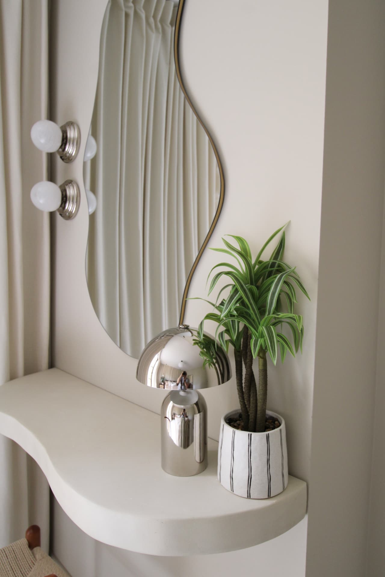 The curtain room: floor-to-ceiling cream curtains, a dark wood bed and rattan bedside table