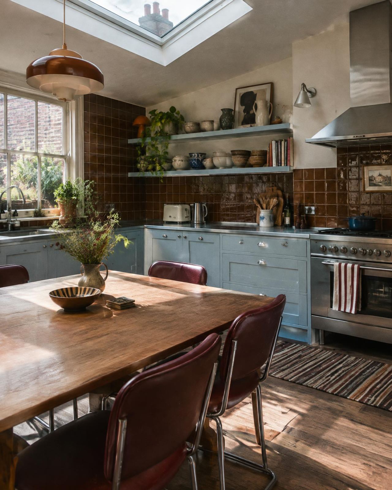 Powder blue kitchen with brown tiles and a skylight