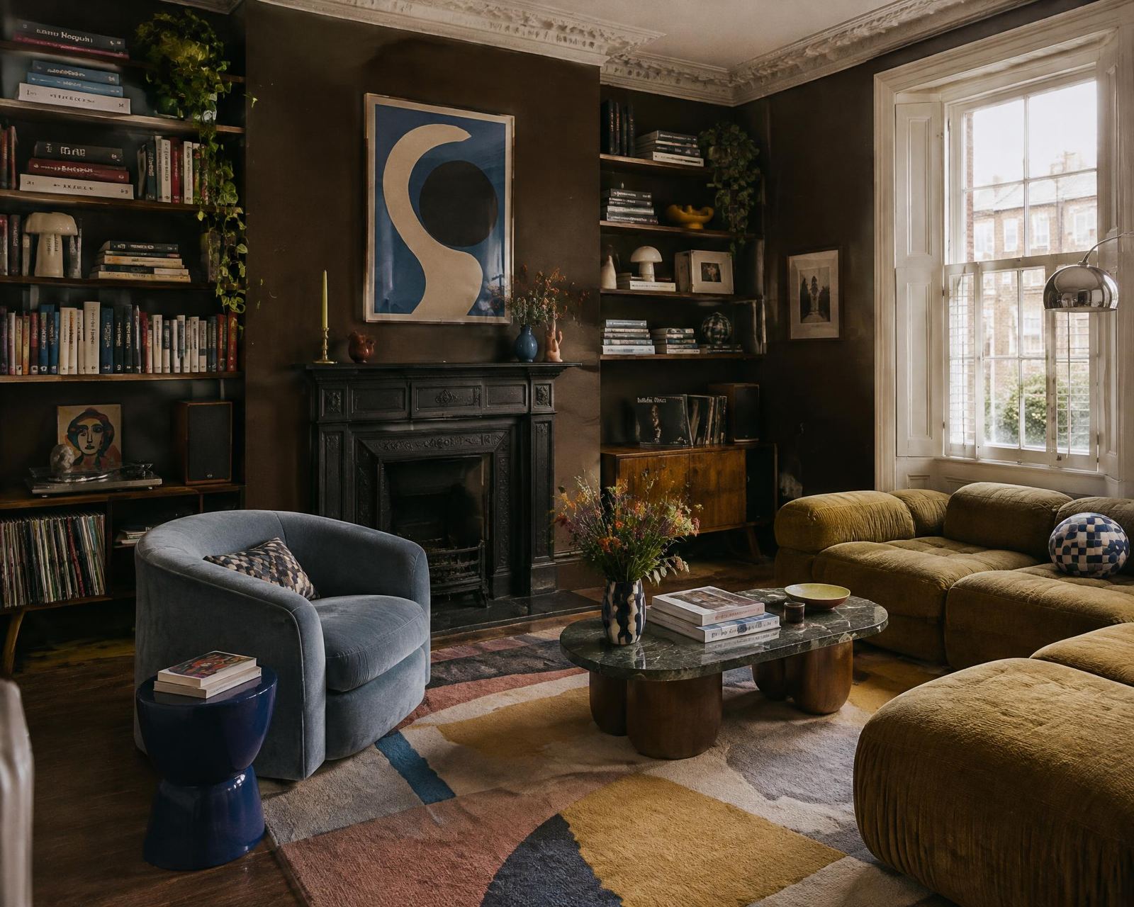 Chocolate brown lounge with bookshelves and a blue velvet armchair
