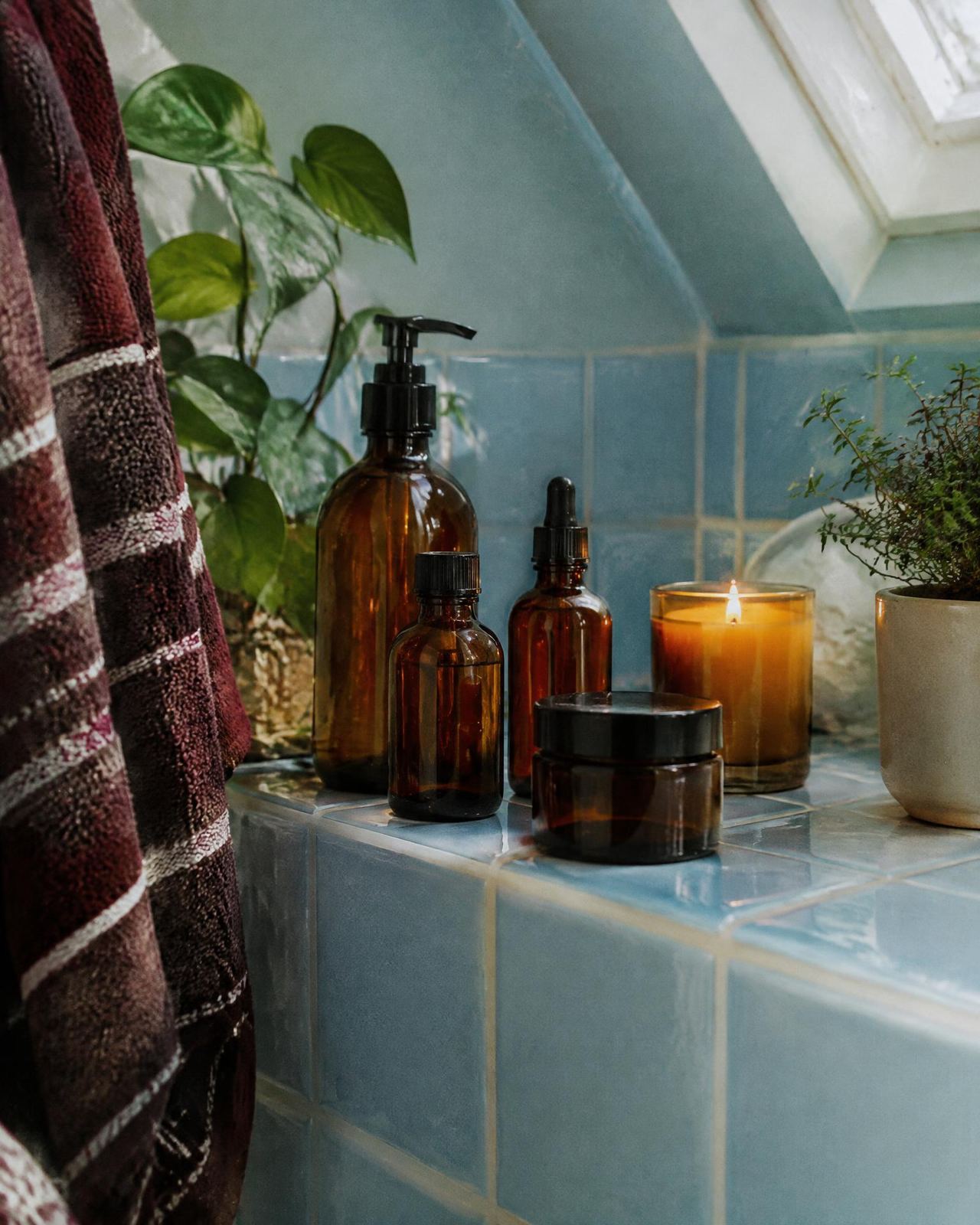 Amber skincare bottles on a blue tiled bathroom shelf
